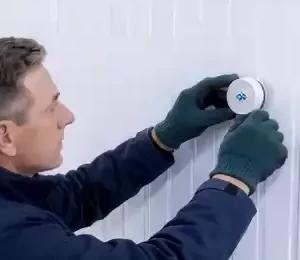 Técnico instalando un sensor GEYBOS GB-TB en la pared de una cámara frigorífica